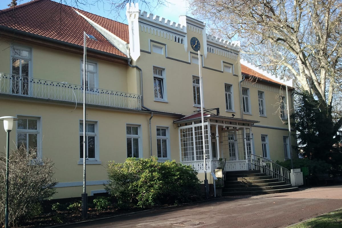 Altes Rathaus in Laatzen: historisches Gebäude mit gelber Fassade, Zinnengiebel und Turmuhr, heute Standesamt